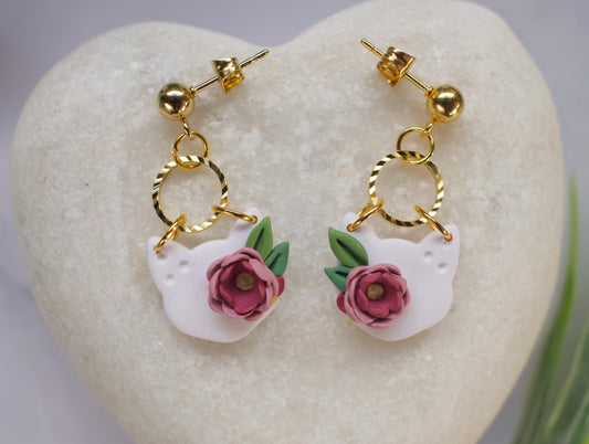 Pair of cat head earrings with floral designs on a heart-shaped stone