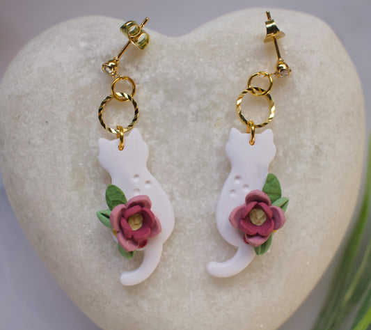 Cat-shaped earrings with floral details on a heart-shaped stone.
