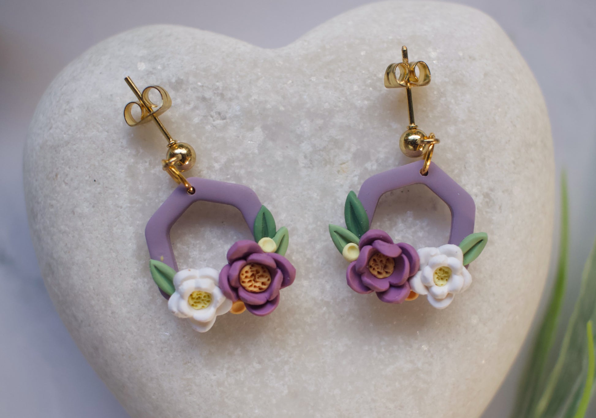 Purple hexagon floral earrings on a heart-shaped stone