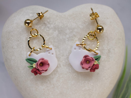 Pair of cat head earrings with floral designs on a heart-shaped stone