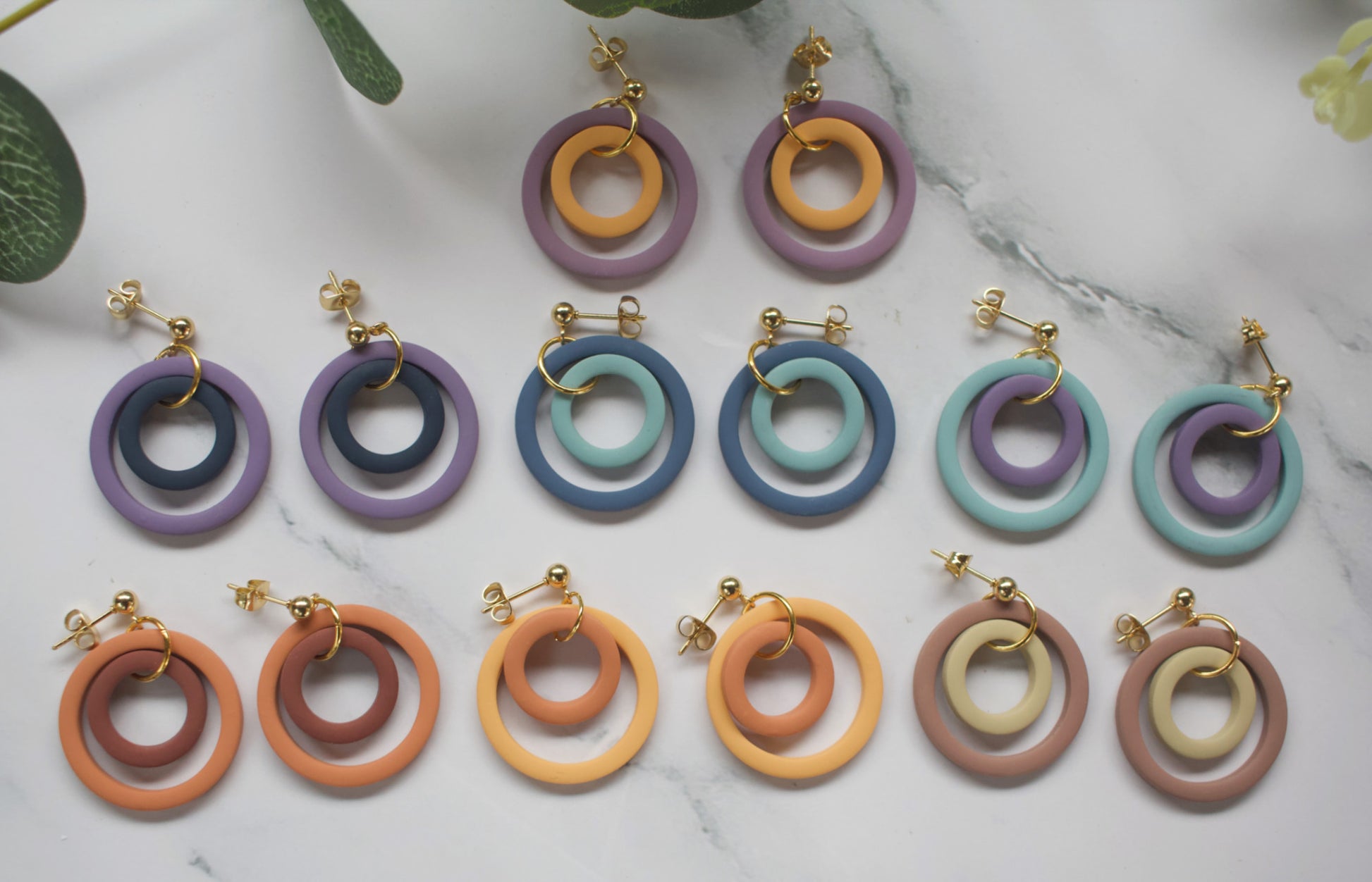 Collection of colourful concentric circular earrings on a marble surface