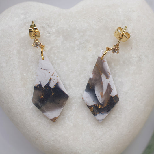Marbled teardrop earrings with gold accents on a heart-shaped stone