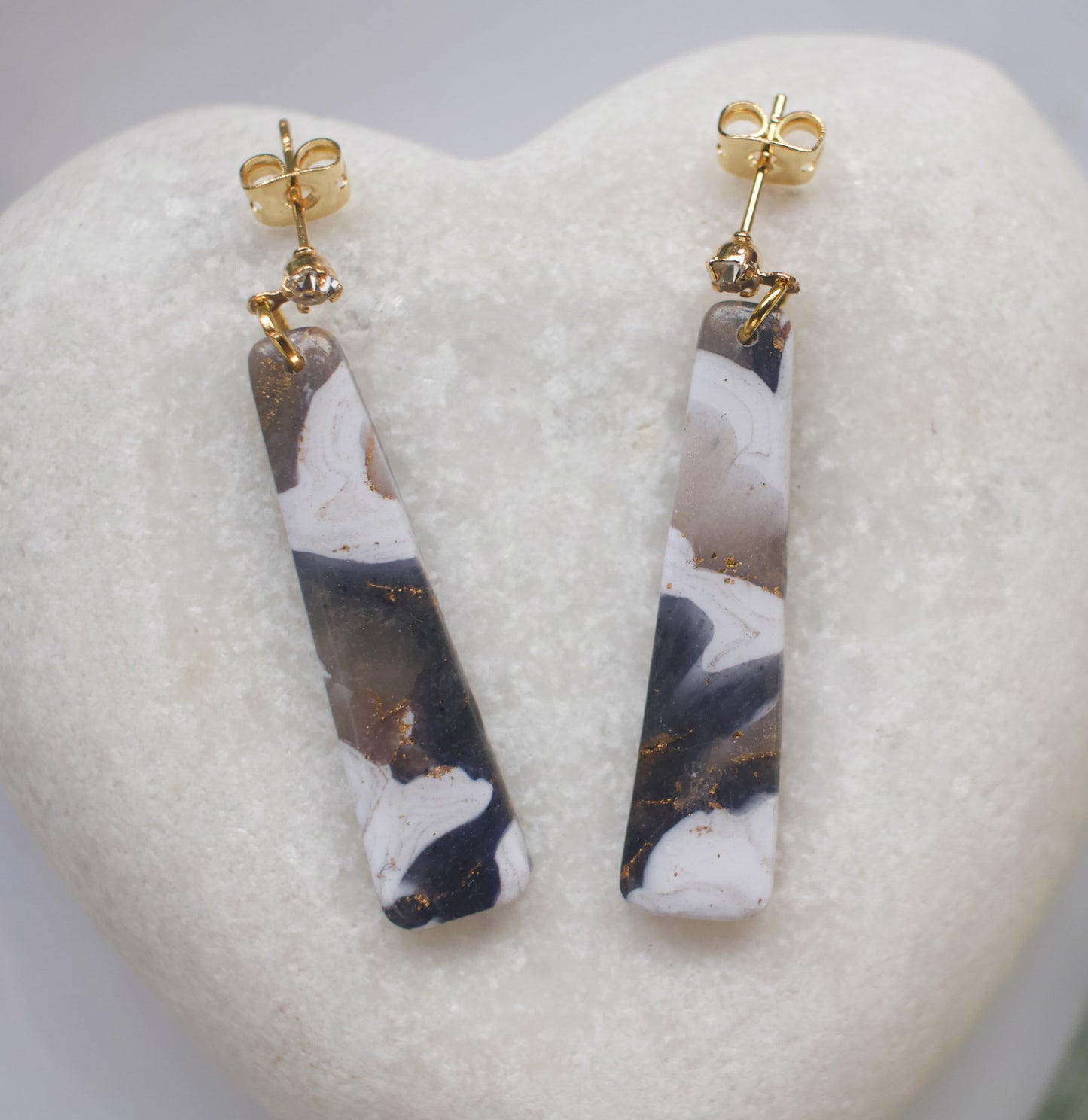 Marbled patterned earrings with gold posts on a heart-shaped stone