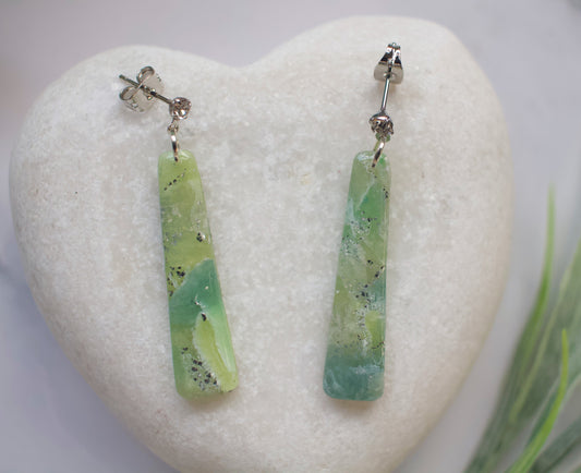 Green bar-shaped earrings on a white heart-shaped stone