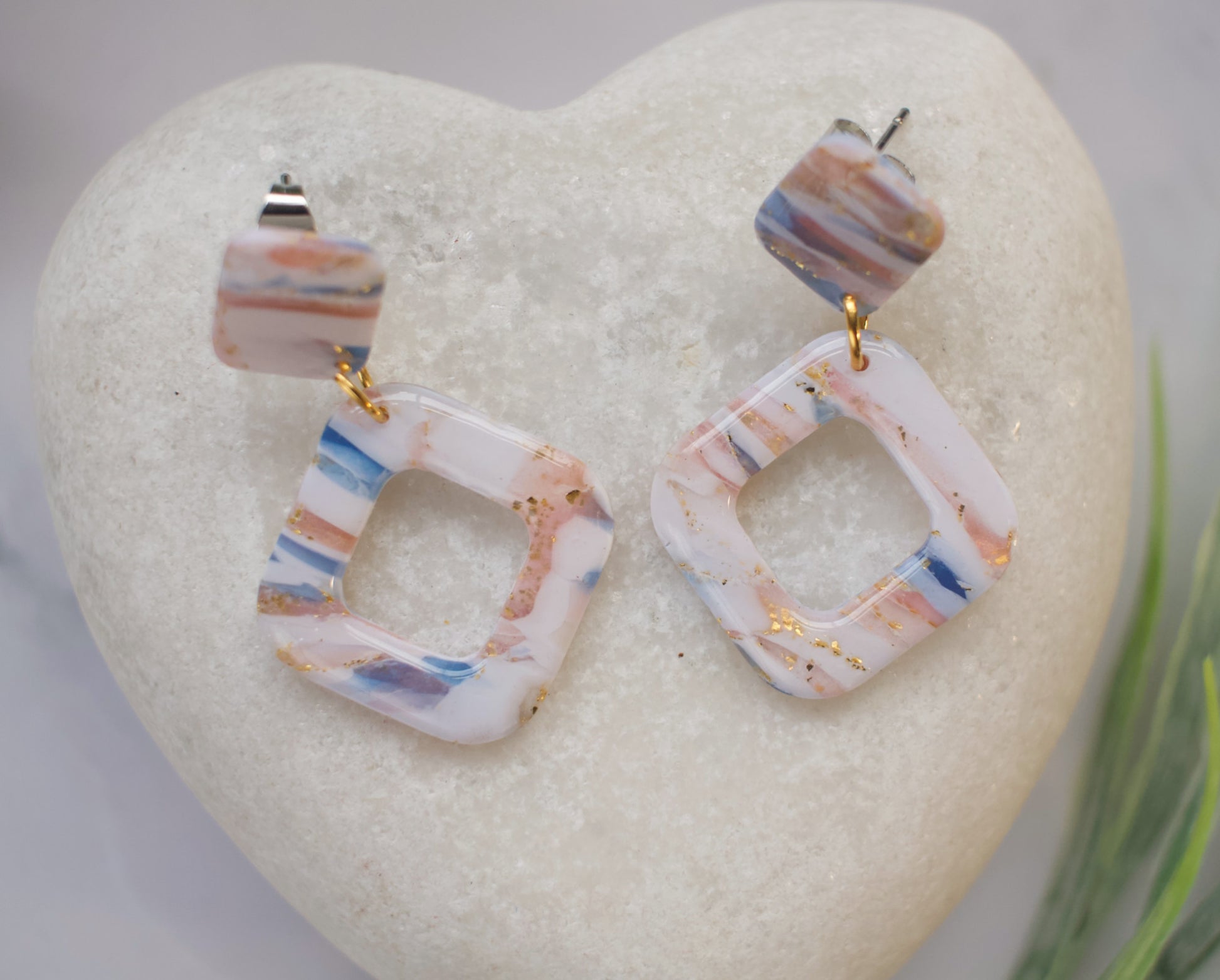 Colorful geometric earrings on a heart-shaped stone