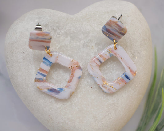 Colorful geometric earrings on a heart-shaped stone