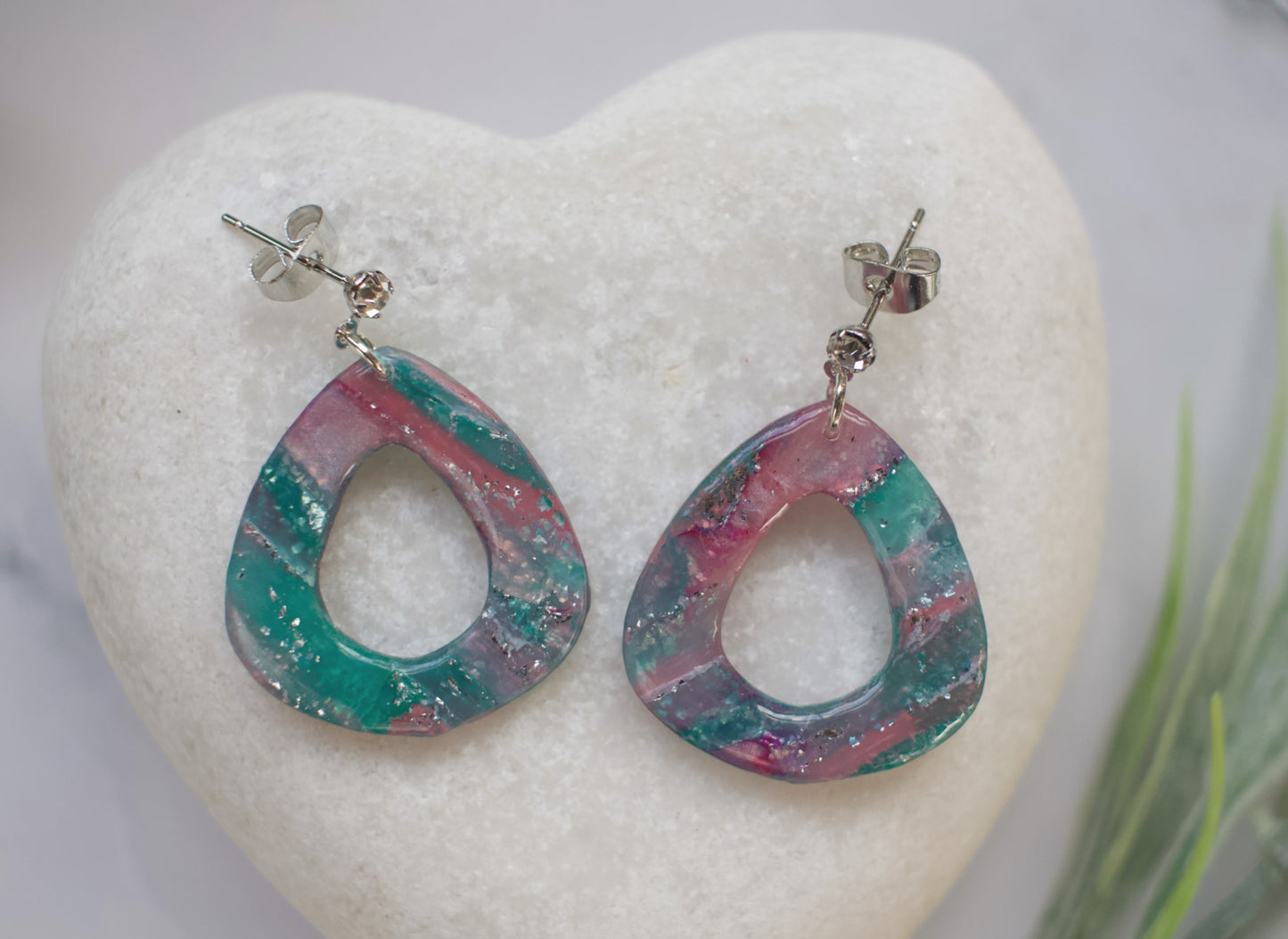 Multicolored teardrop earrings on a white heart-shaped stone