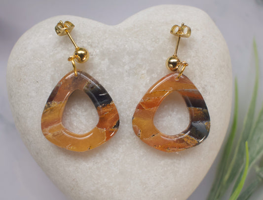 Pair of teardrop-shaped earrings with gold accents on a heart-shaped stone.
