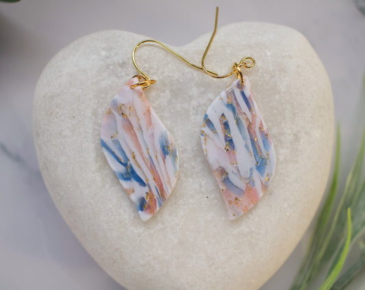 Multicolored earrings on a heart-shaped stone with a blurred background