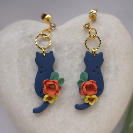 Cat-shaped earrings with floral details on a heart-shaped stone.