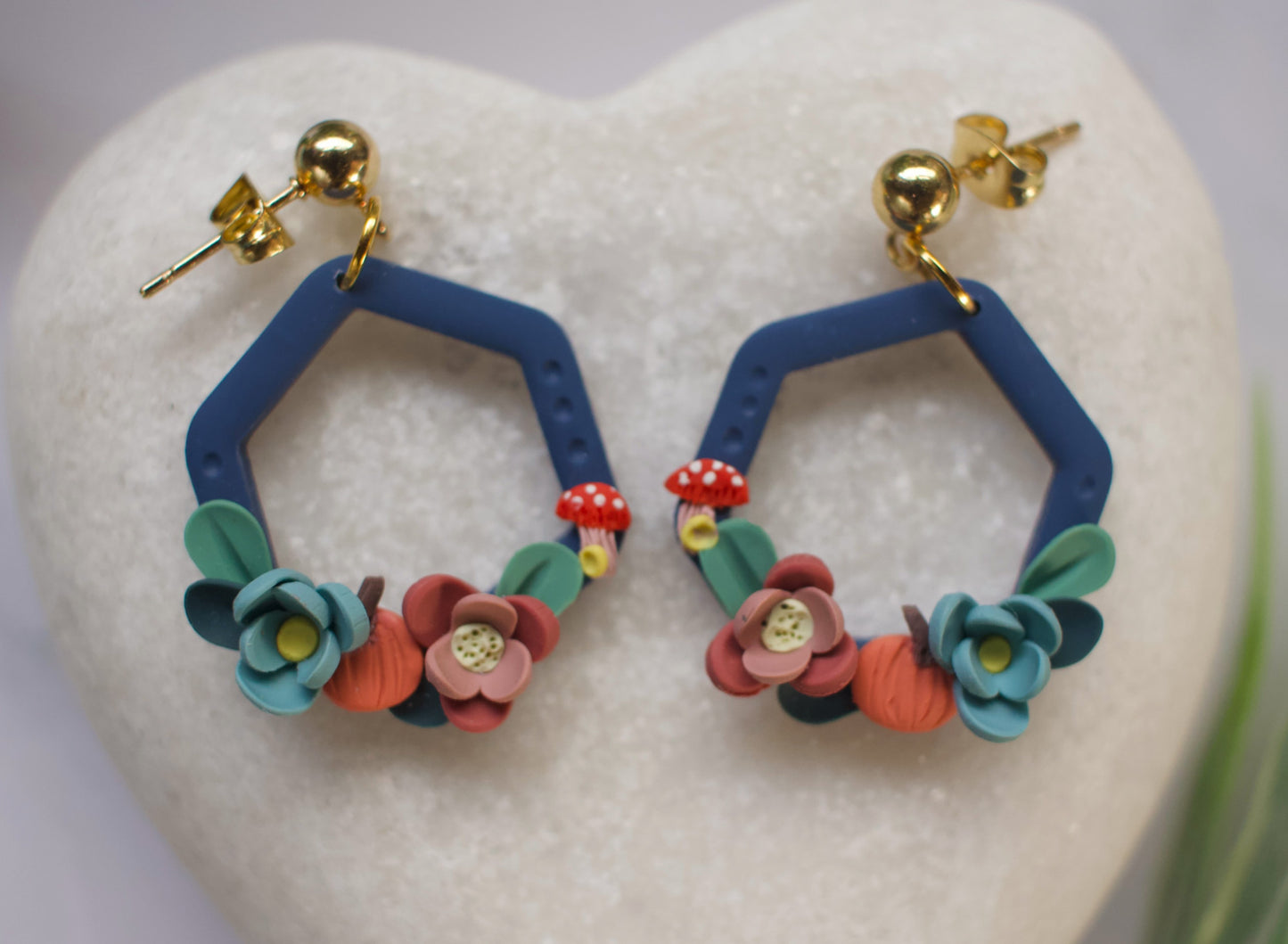 Hexagonal earrings with floral designs on a heart-shaped stone