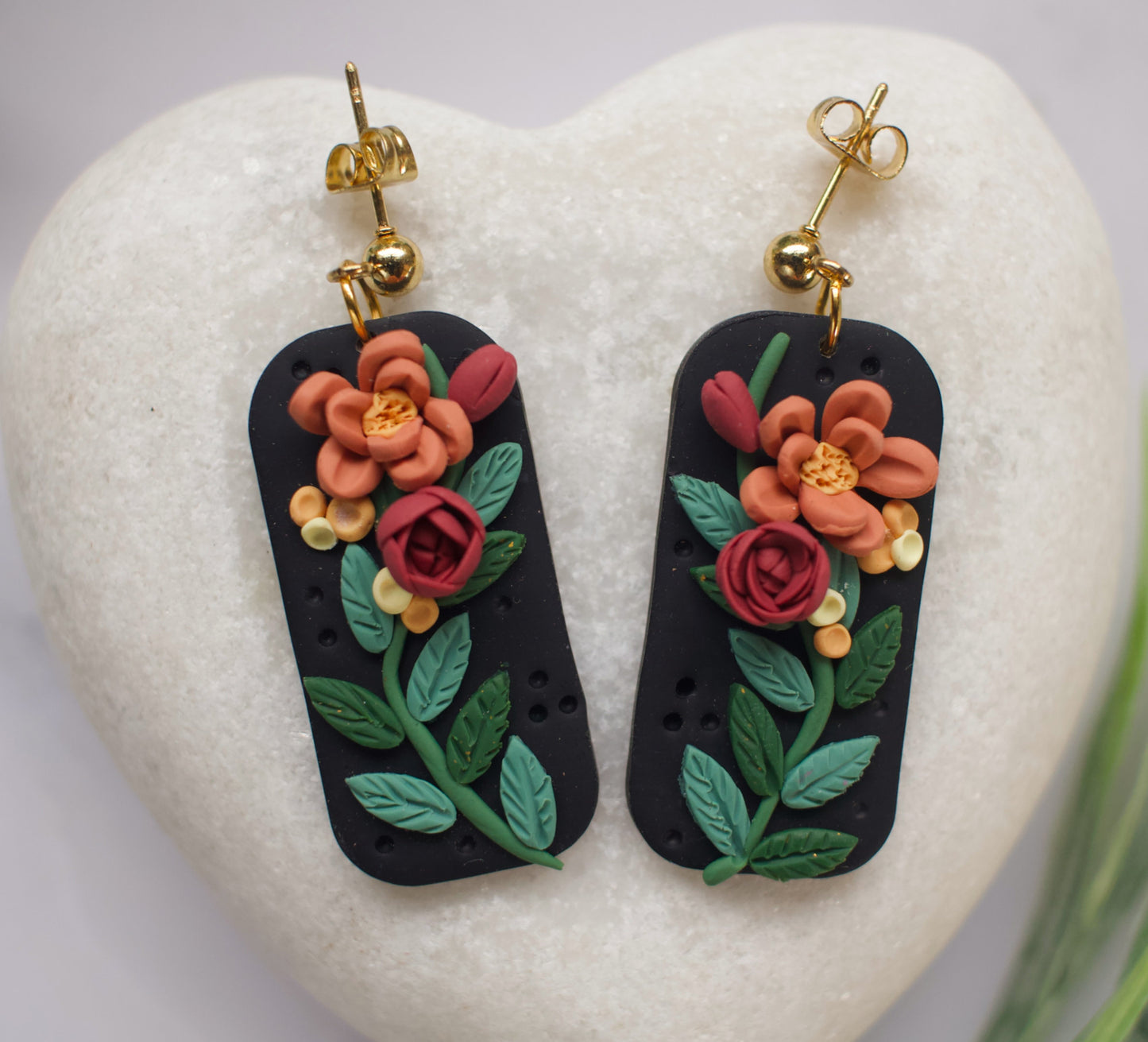 Pair of floral earrings on a heart-shaped stone