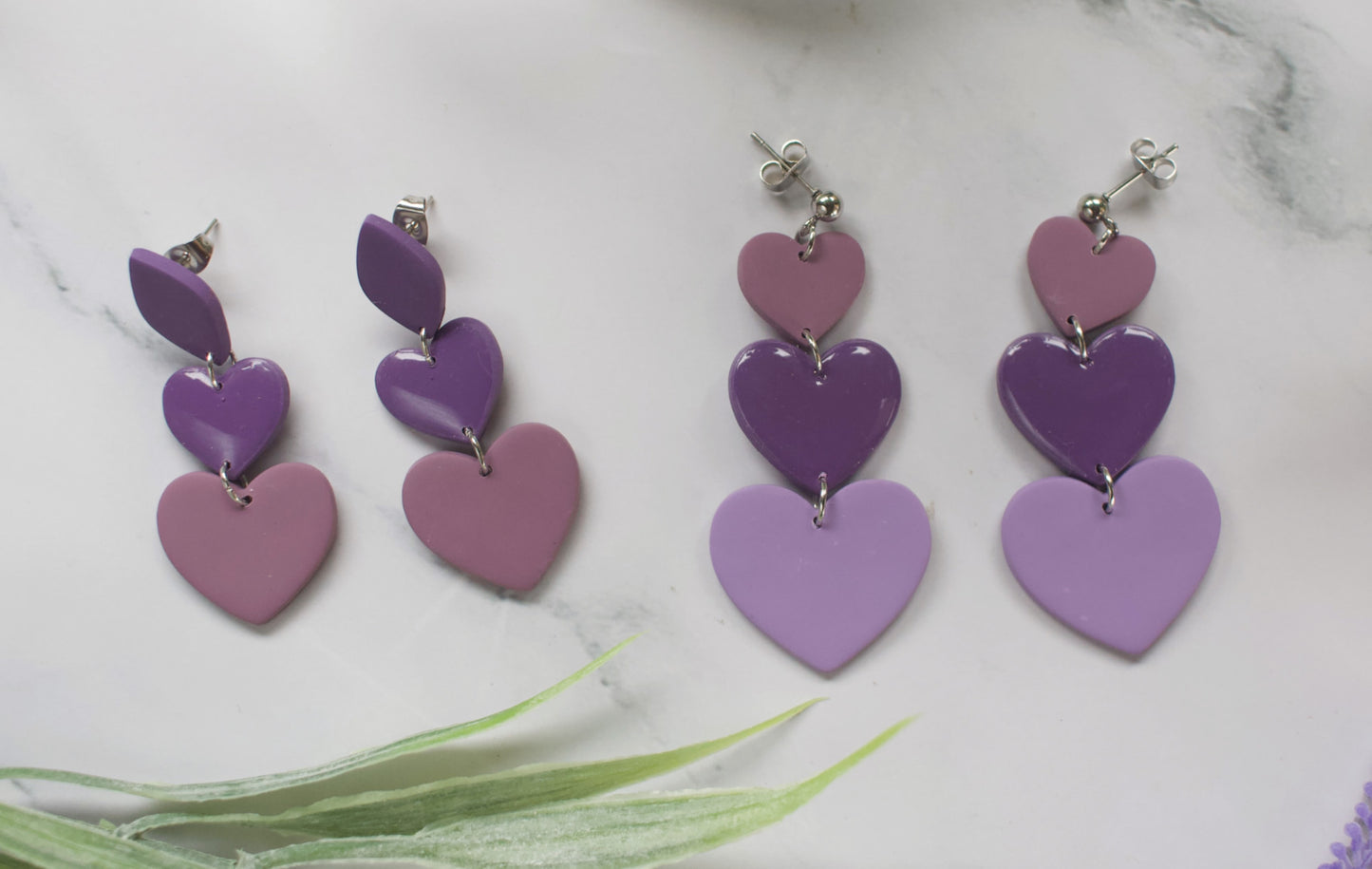 Purple heart-shaped earrings on a white background